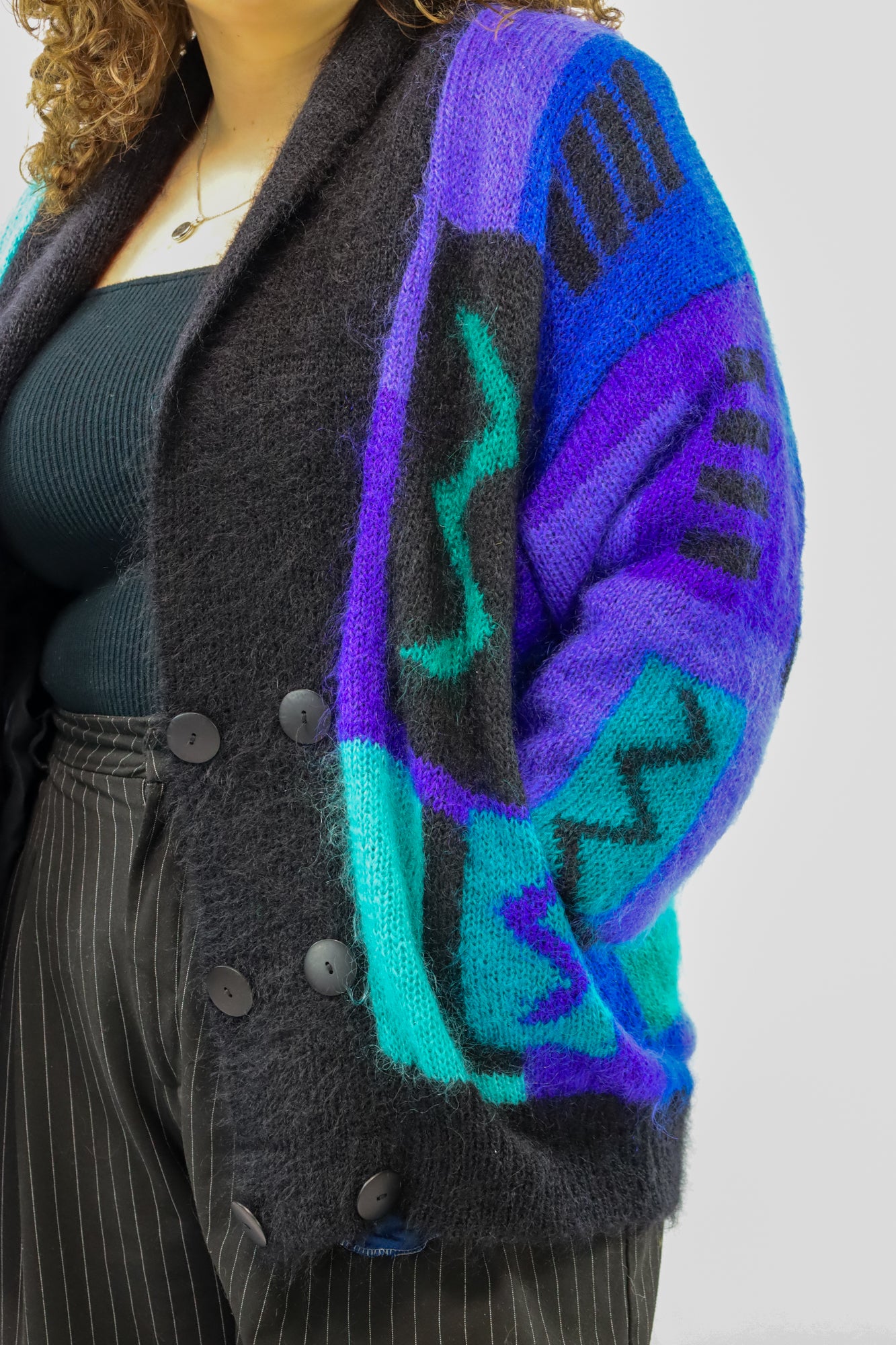 (EN) Close-up of a soft mohair cardigan with a unique blue-toned design.
(NL) Close-up van een zacht mohair vest met een uniek design in blauwtinten.