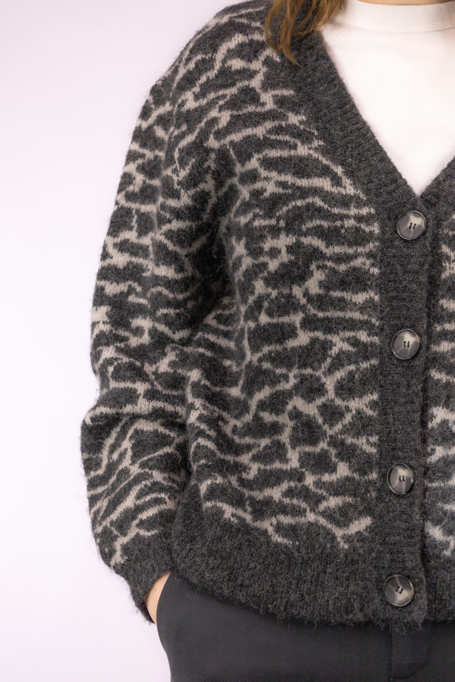 Detail van gebreide stof met grijs-witte dierachtige print op vintage cropped vest