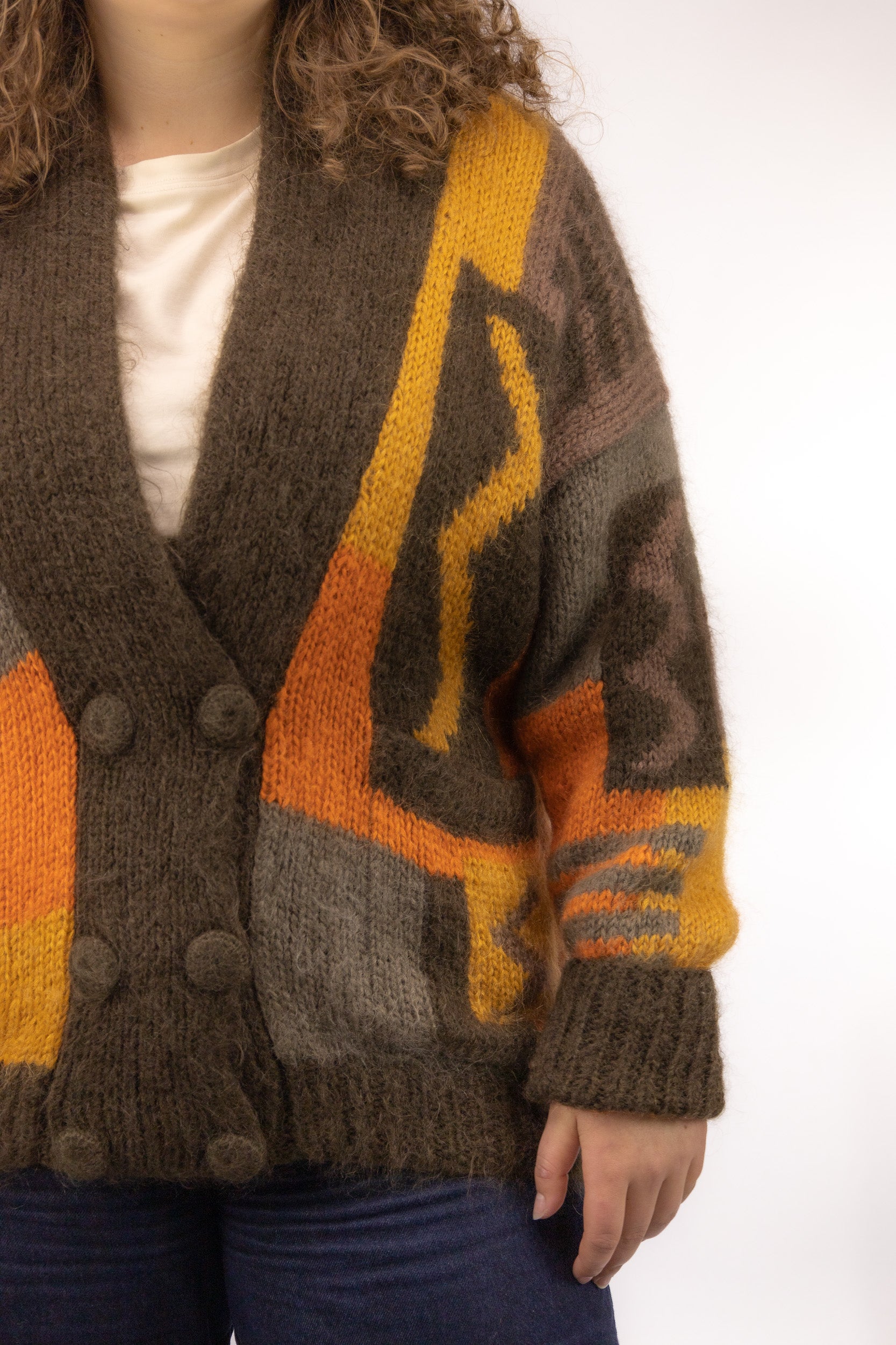 Detail van zacht handgebreid vintage vest in mohair mix met pluizige textuur en retro patroon
