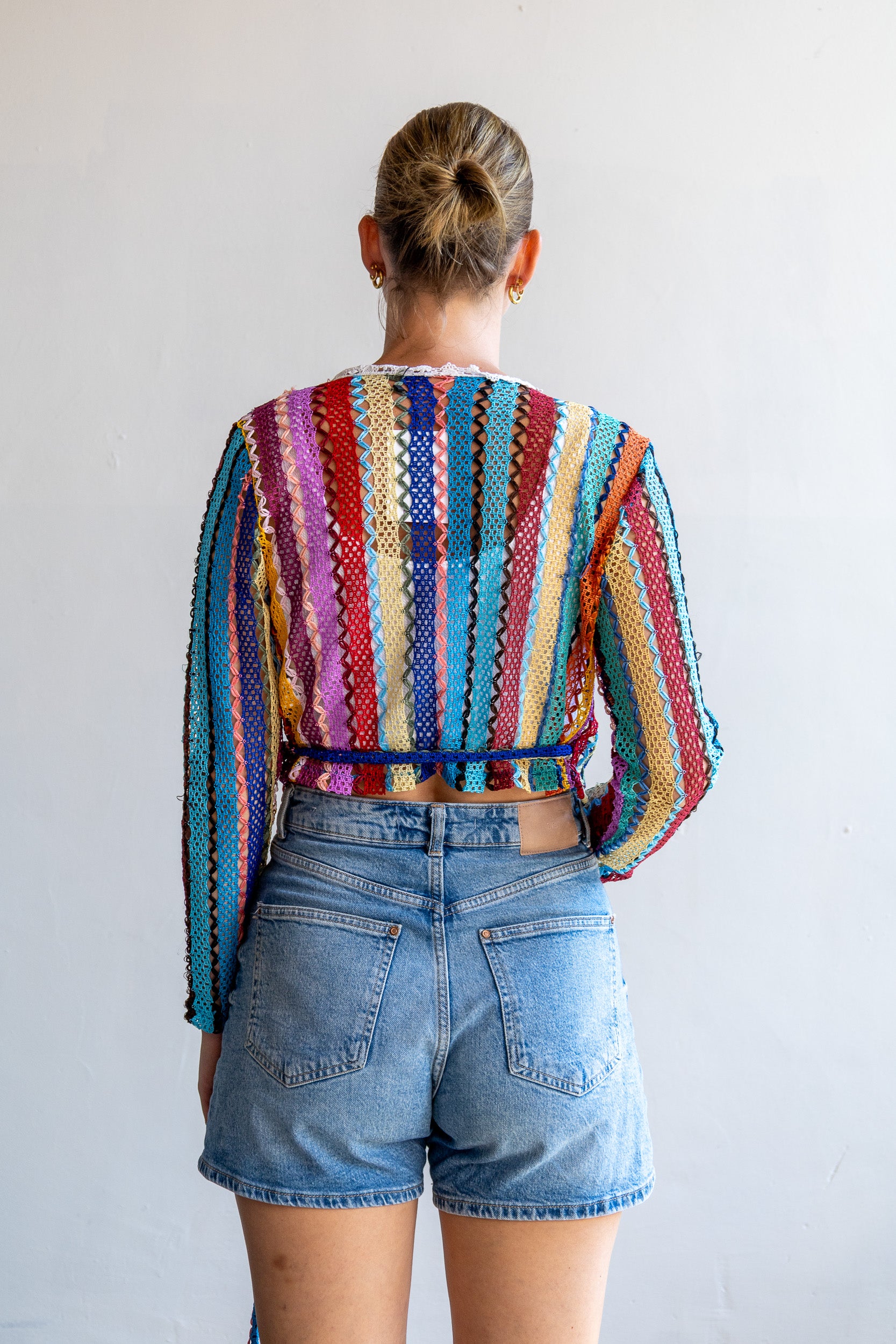 Achterzijde van de one of a kind vintage open gebreide top met kleurrijk patroon.
