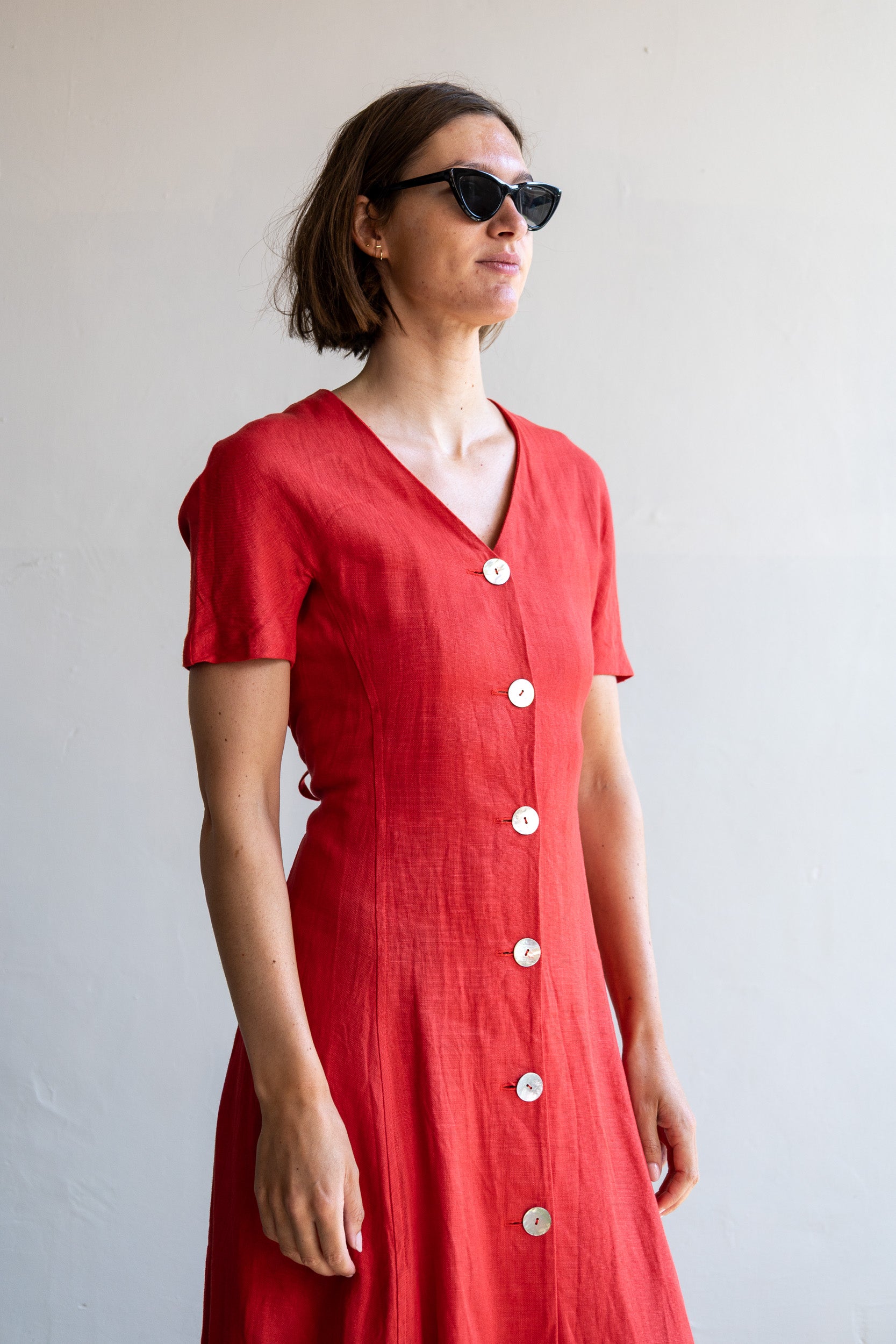Vintage rode linnen jurk met schelpknopen, korte mouwen en lange pasvorm.