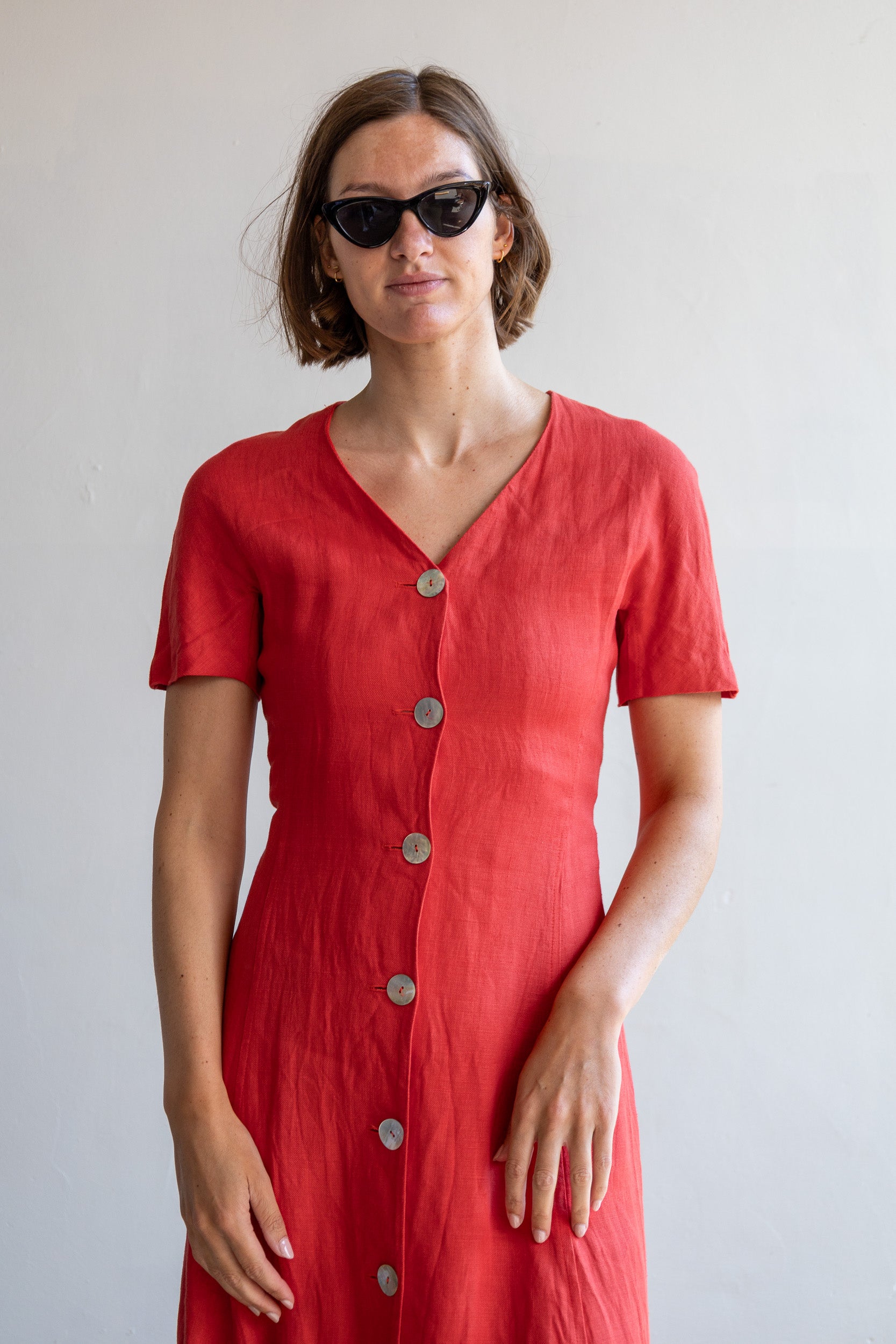 Detail van de vintage linnen jurk met schelpknopen en rode linnen stof.