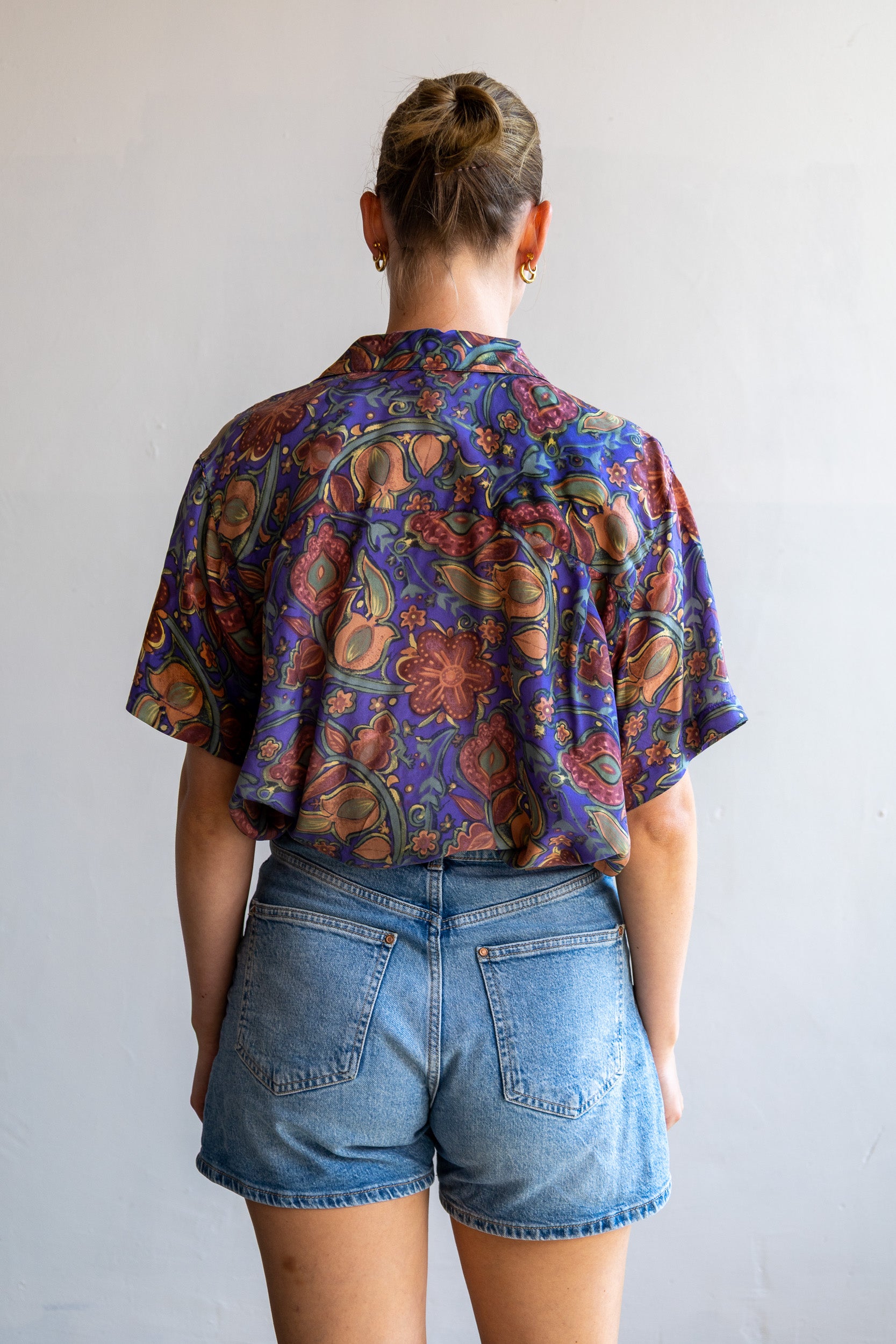 Achterzijde van de vintage zijden blouse met doorlopende paisley bloemenprint en soepelvallende pasvorm.