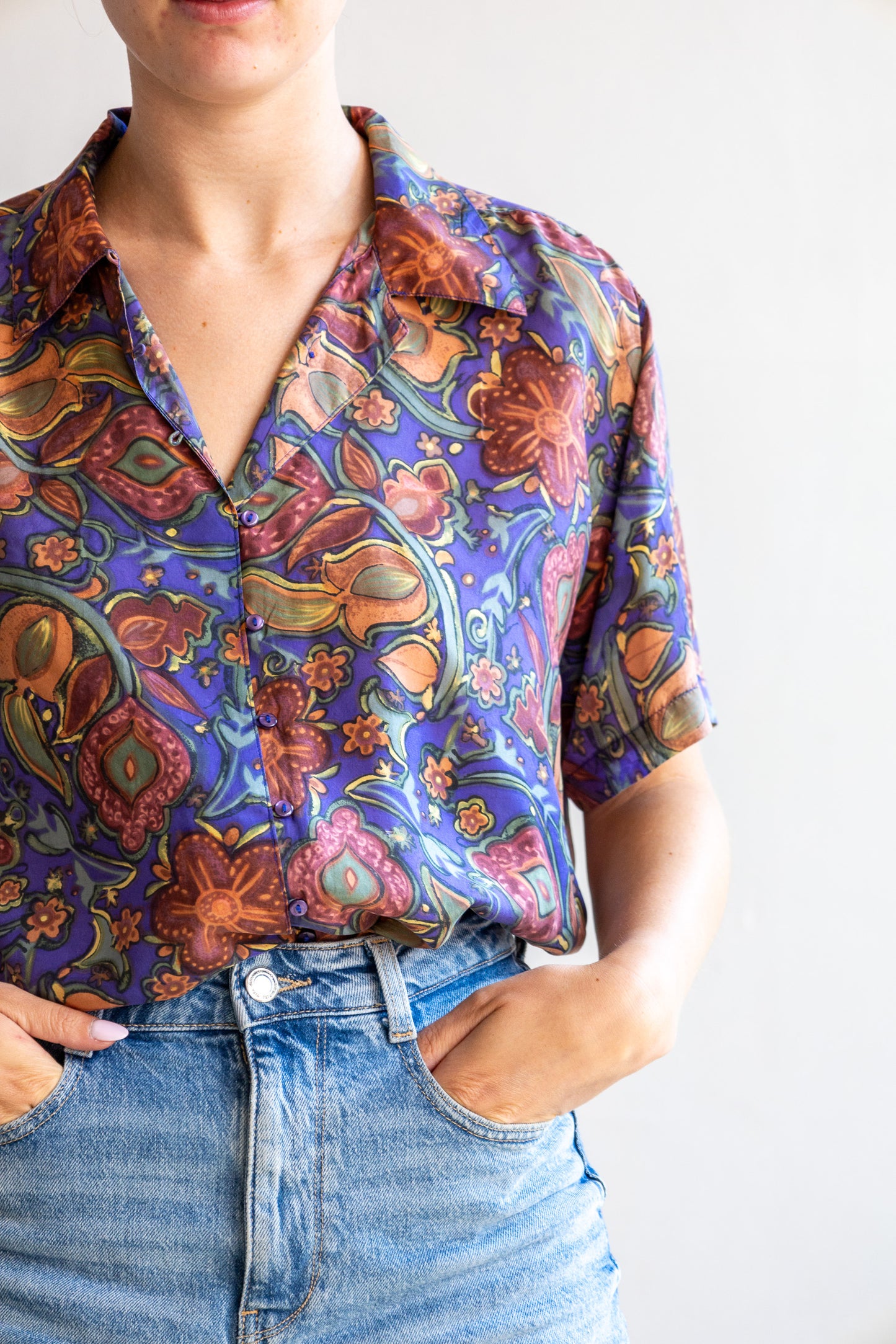 Detail van de vintage zijden blouse met paisley bloemenprint, zijde stof en fijne lusjessluiting.