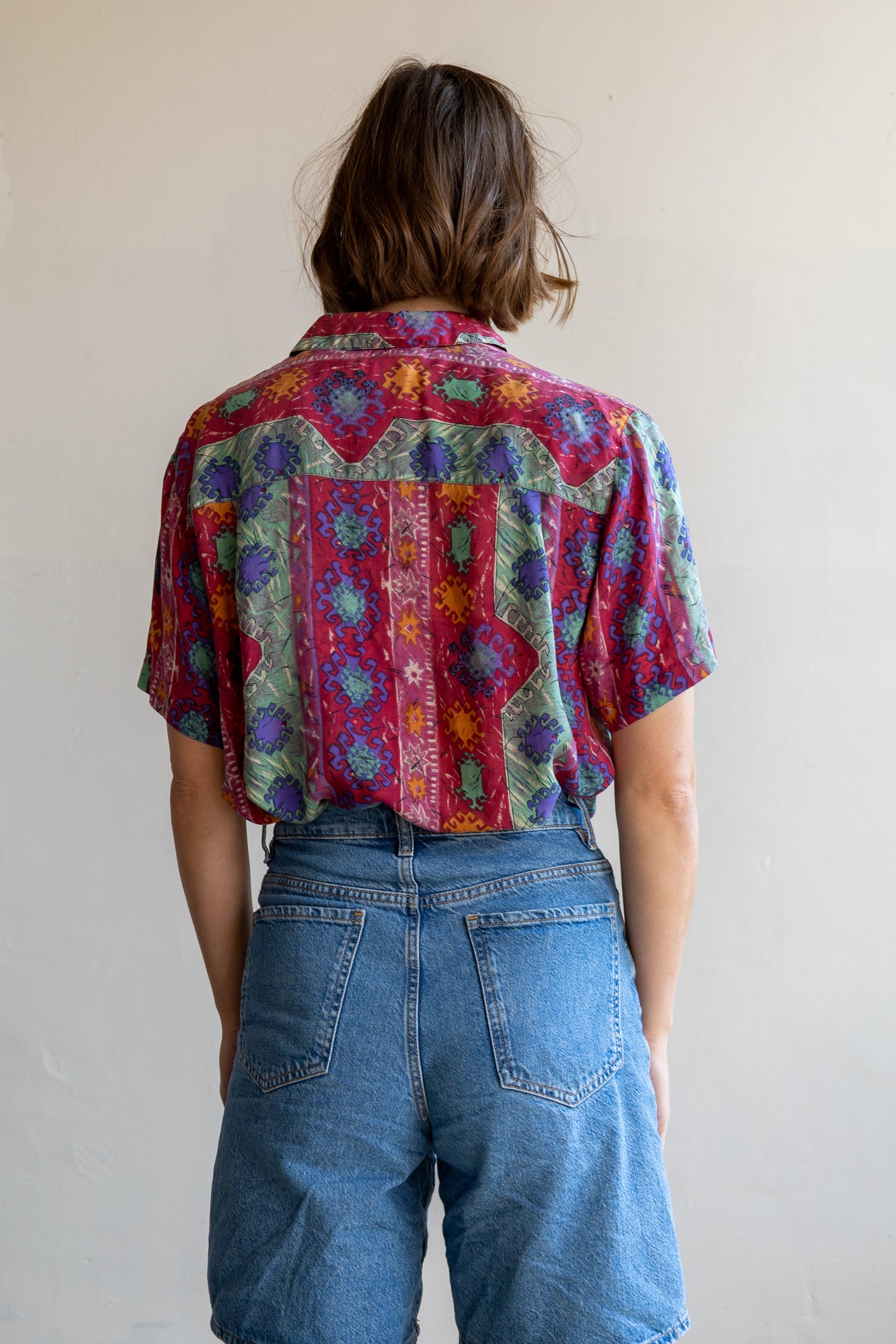 Achterzijde van de vintage zijden blouse met doorlopende paisley bloemenprint en soepelvallende pasvorm.