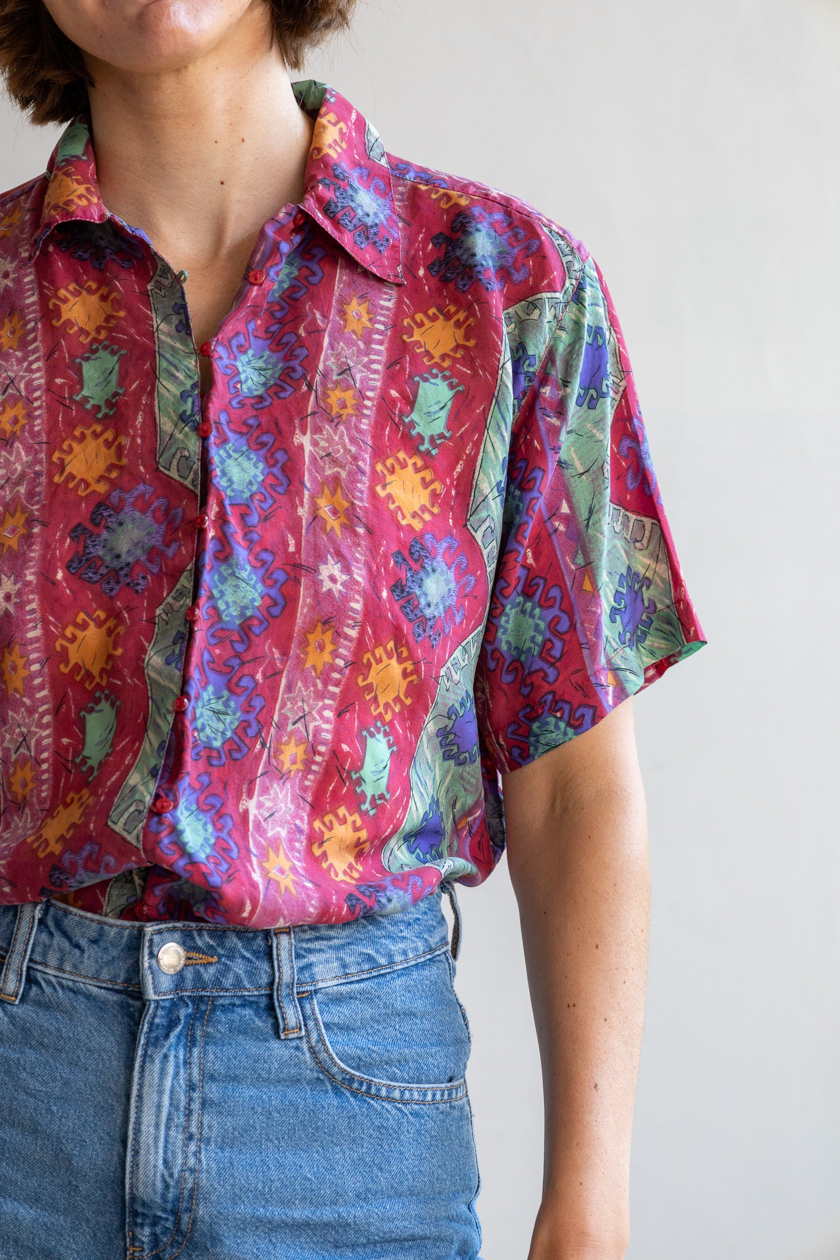 Detail van de vintage zijden blouse met paisley bloemenprint, zijde stof en fijne lusjessluiting.