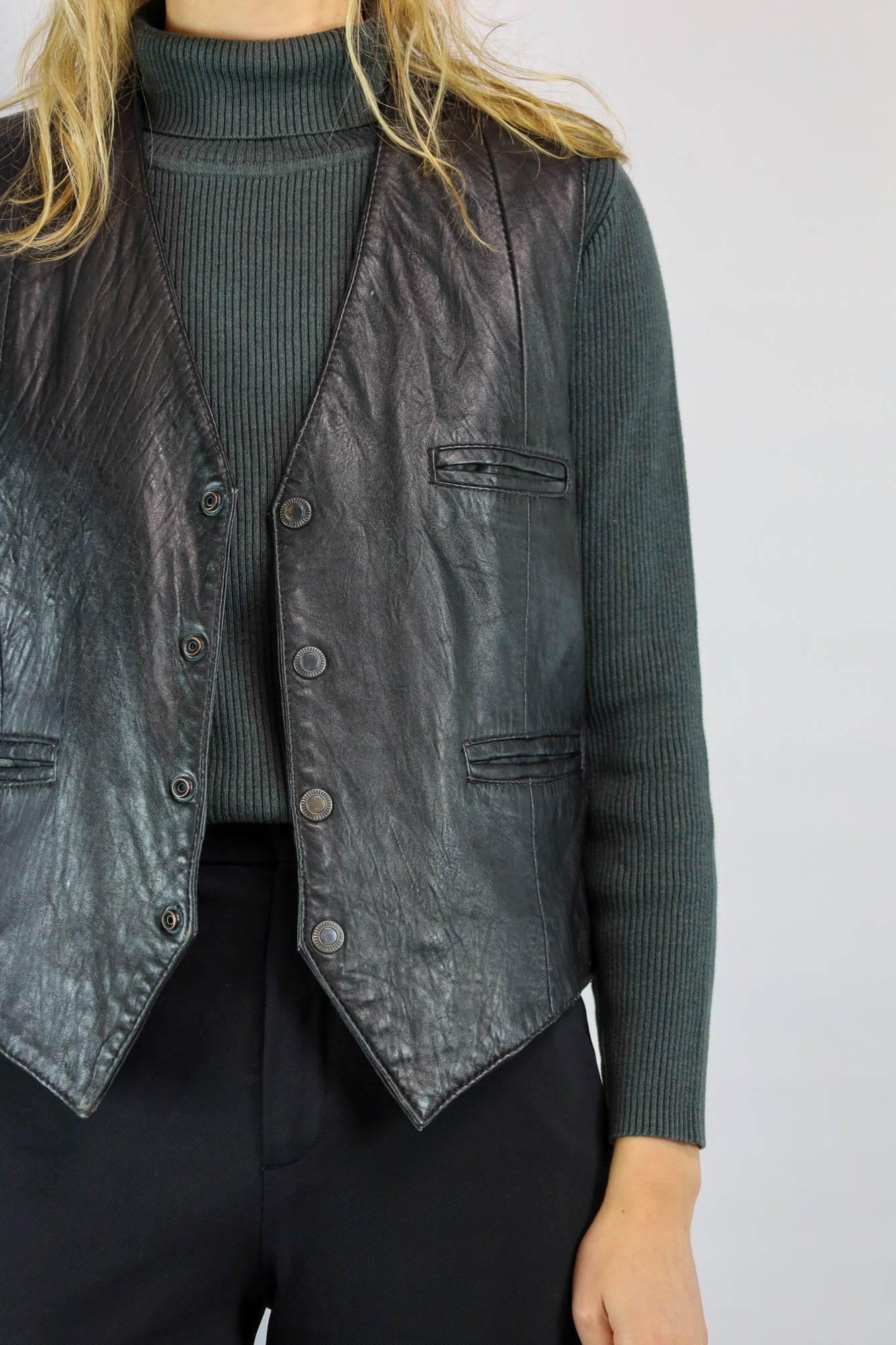 Detail van gevoerd leren gilet met tijdloze uitstraling.