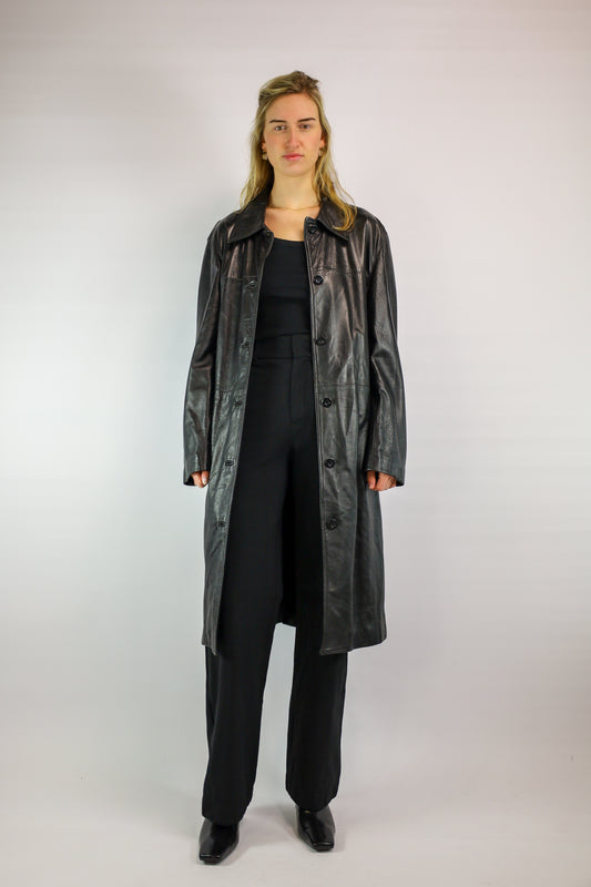 (EN) Vintage black leather trench coat, knee-length with snap button closure.
(NL) Vintage zwarte leren trenchcoat, knielang met drukknopen.