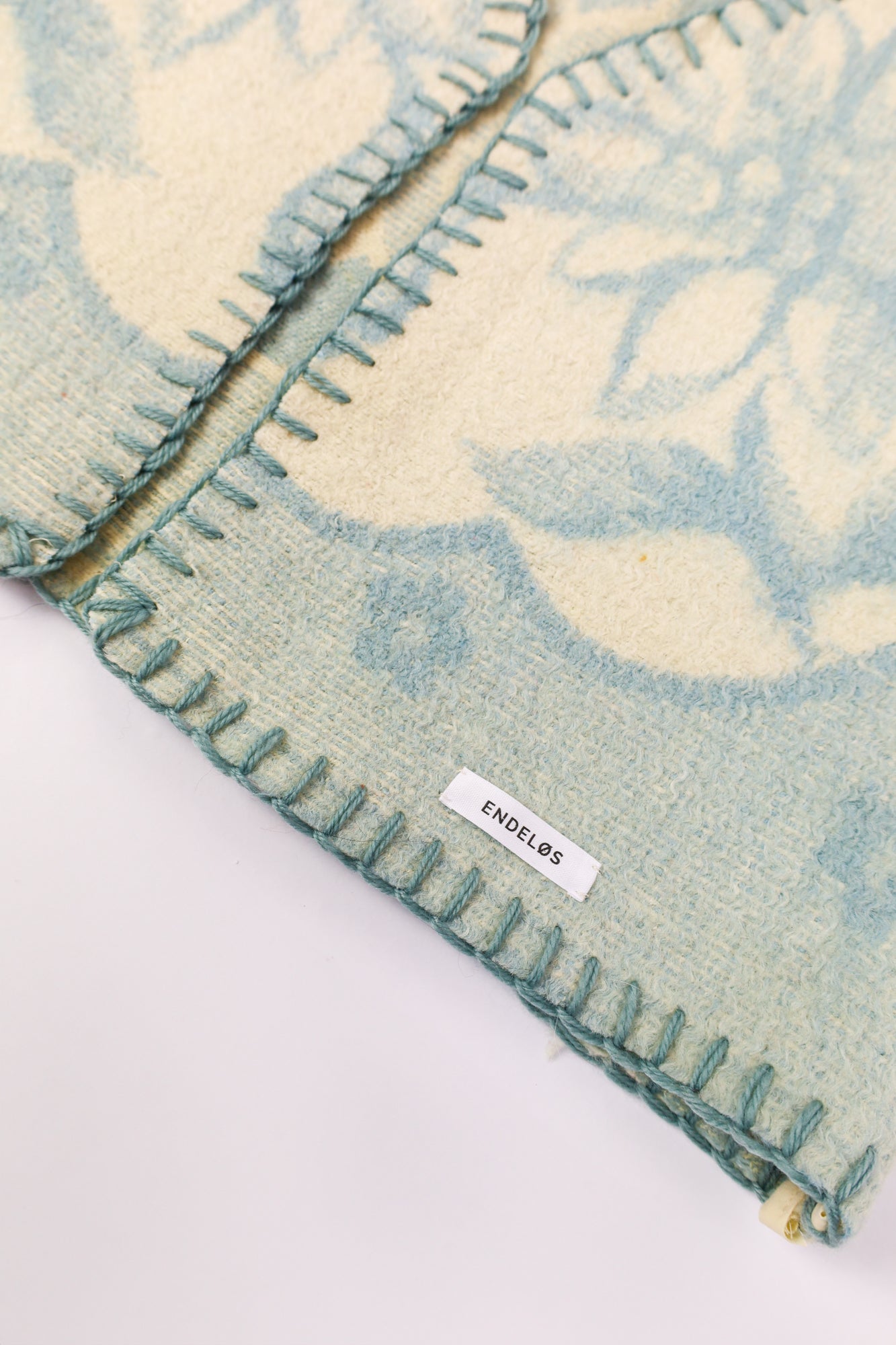 Close-up of the thick wool texture with matching blue stitching.