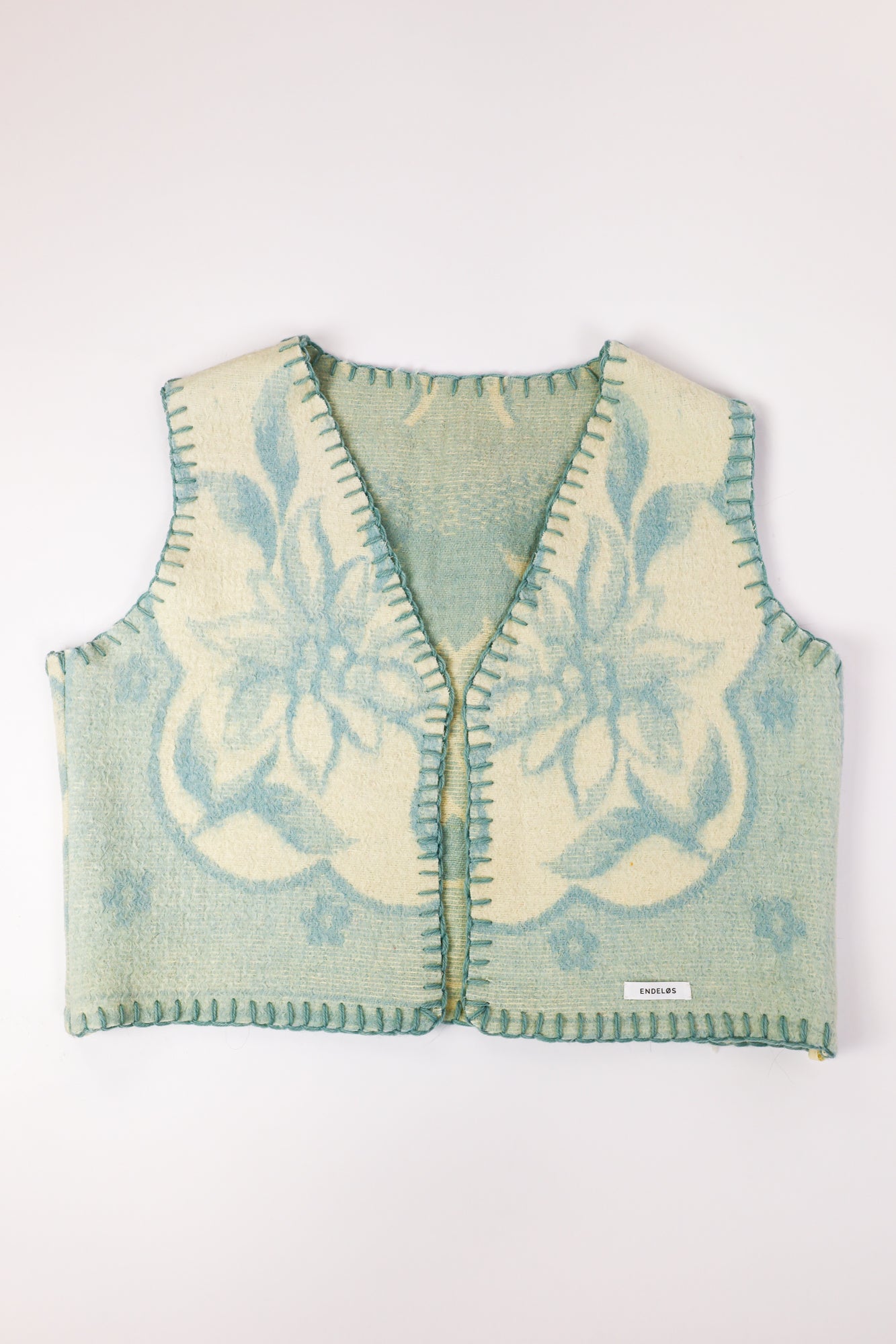 Front view of the handmade oversized vest in a soft blue wool fabric.