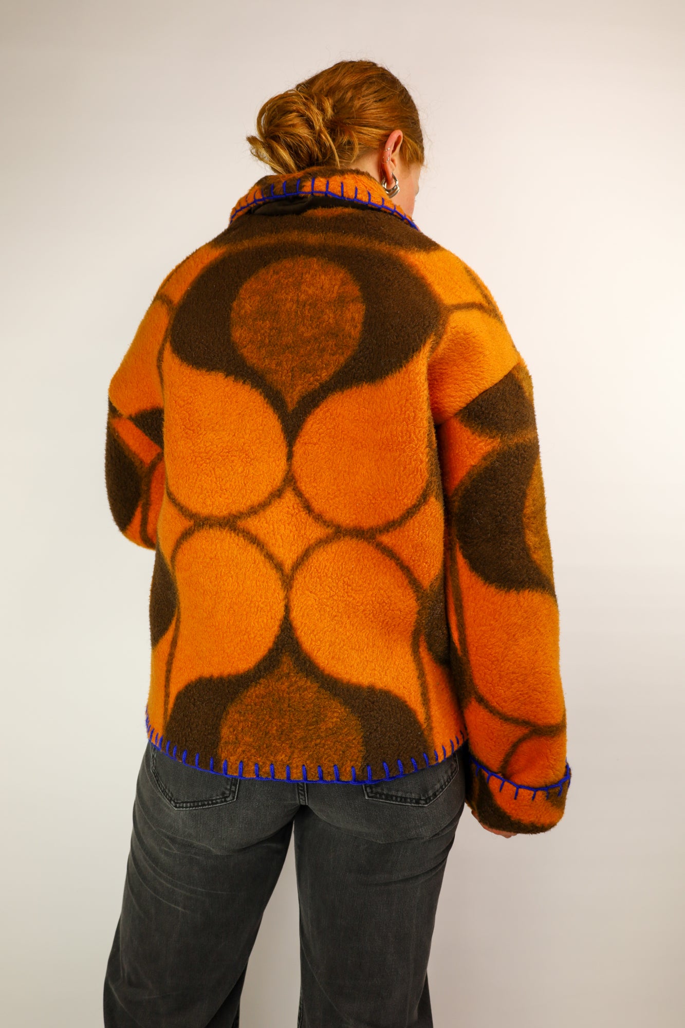 Back view of the oversized coat, showcasing the vibrant retro pattern and relaxed fit