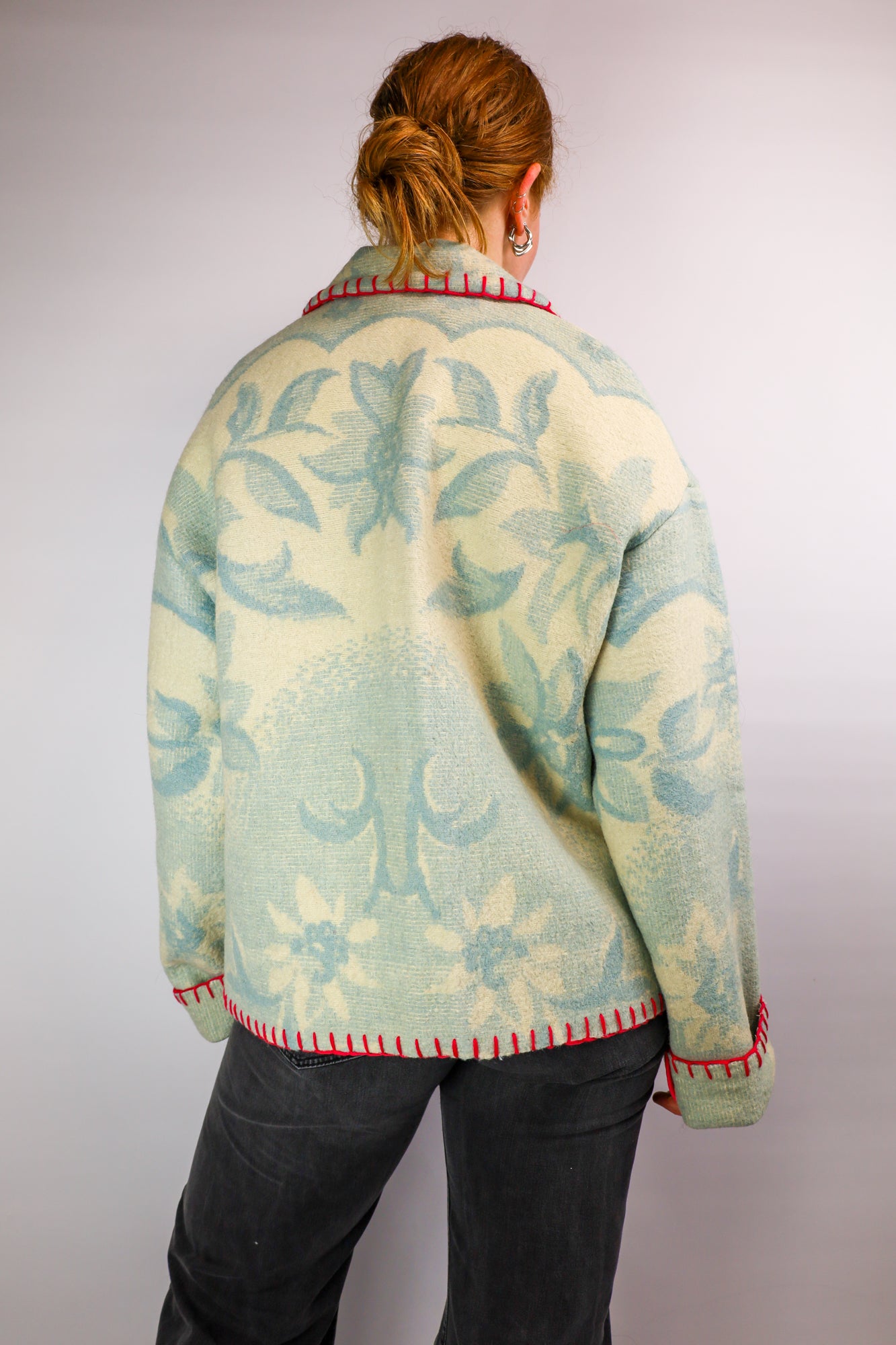 Back view of the oversized coat, showcasing the floral wool texture and relaxed silhouette.