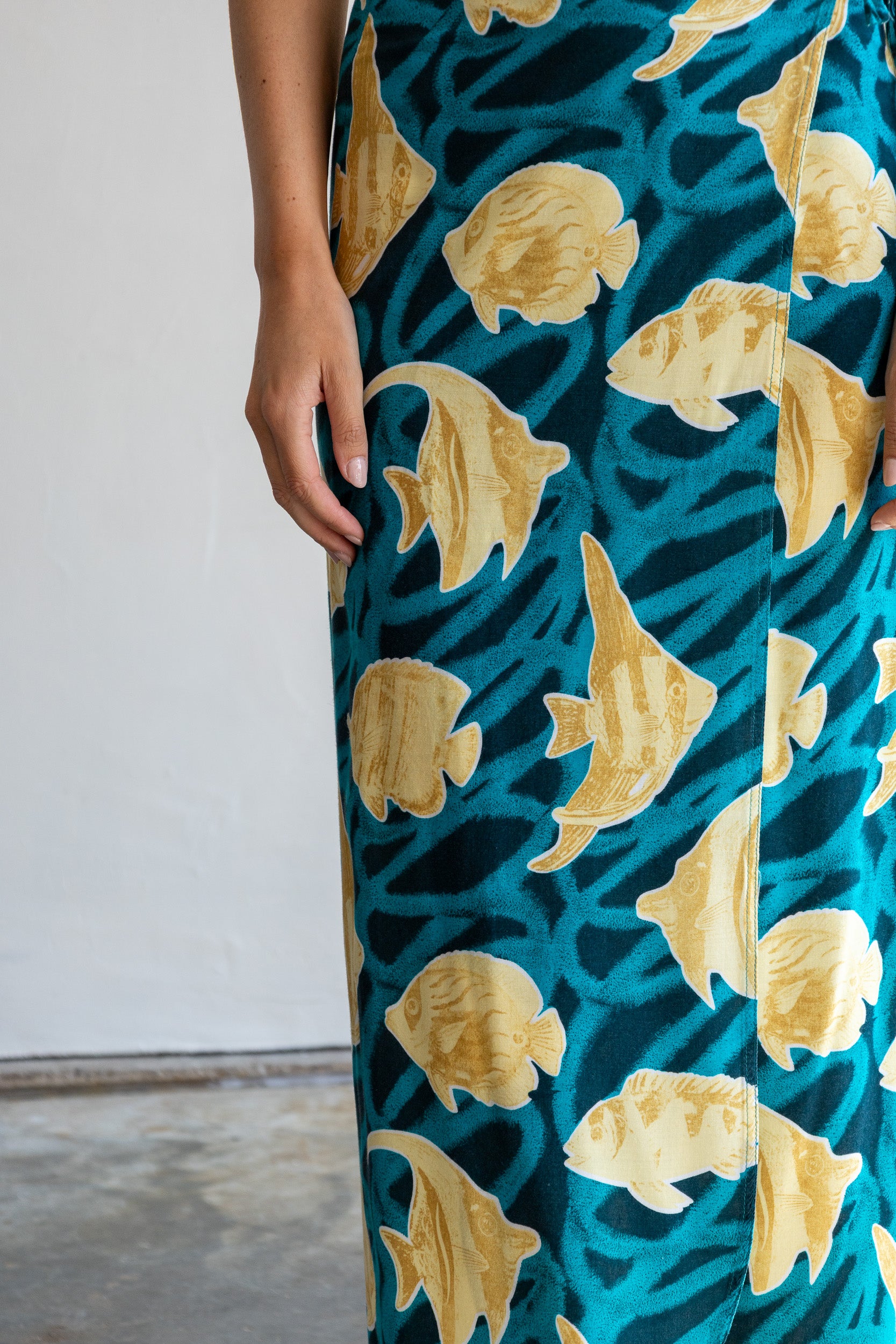 Detail van de vintage wikkelrok met vismotief en groen-goud-zwarte print.