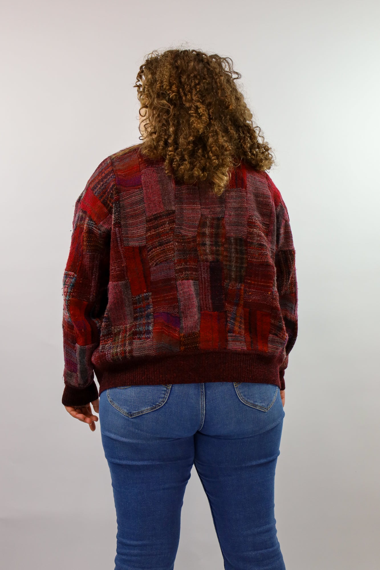 Burgundy vest met speels patchwork design en knopen.