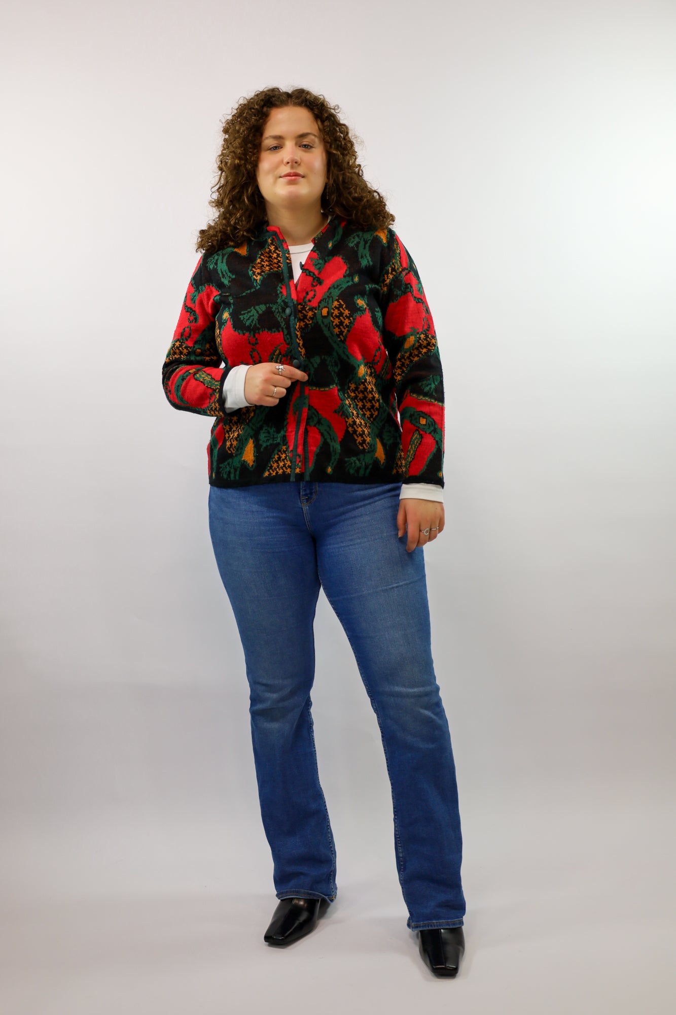 Uniek zwart vest met ingebreid dessin in oranje, rood en groen.