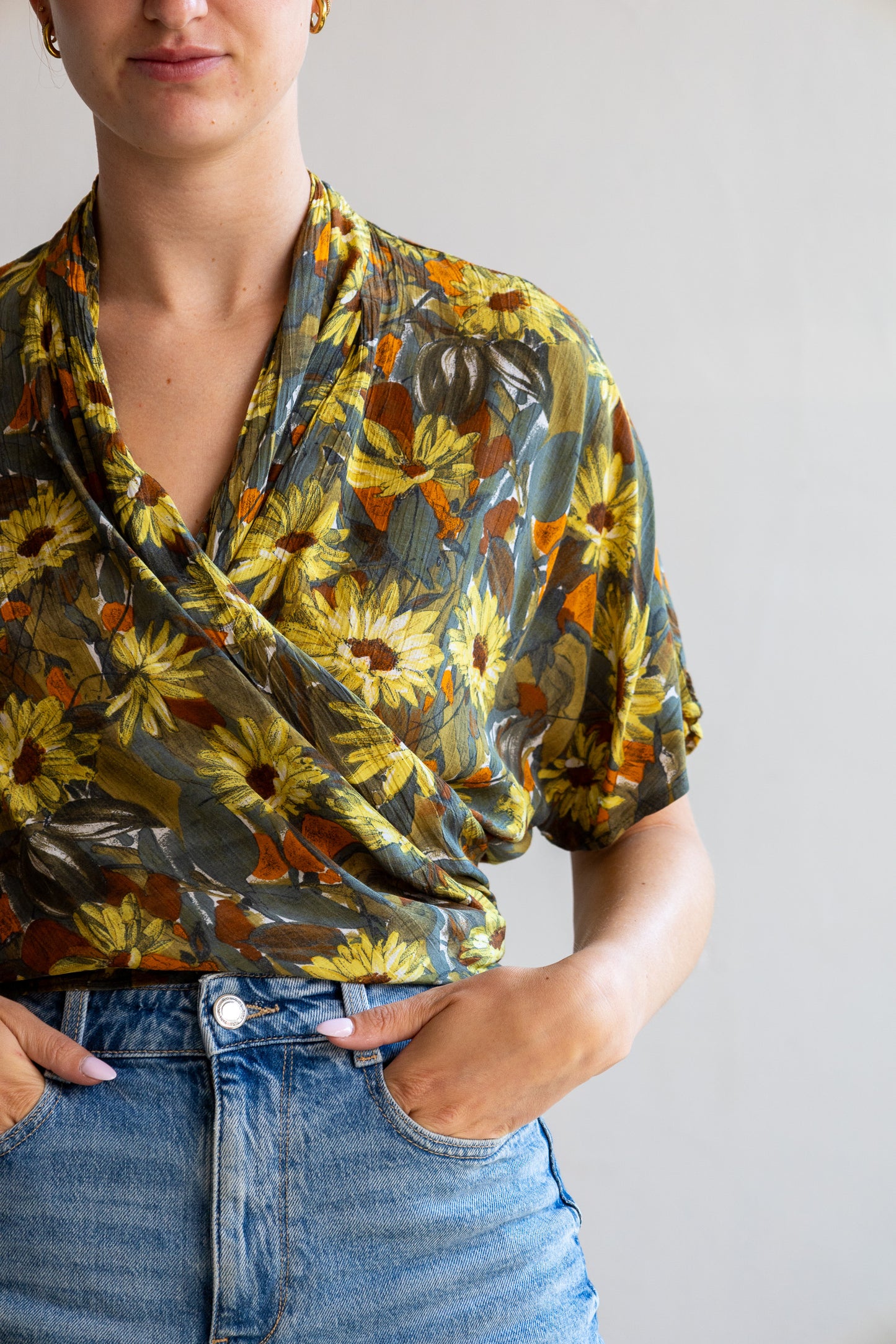 Detail van de vintage zijden wikkelblouse met bloemenprint en zachte zijde stof.