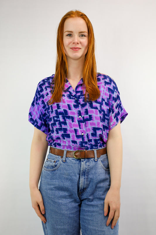 Voorkant van vintage blouse met paarse en blauwe grafische print en parelknopen