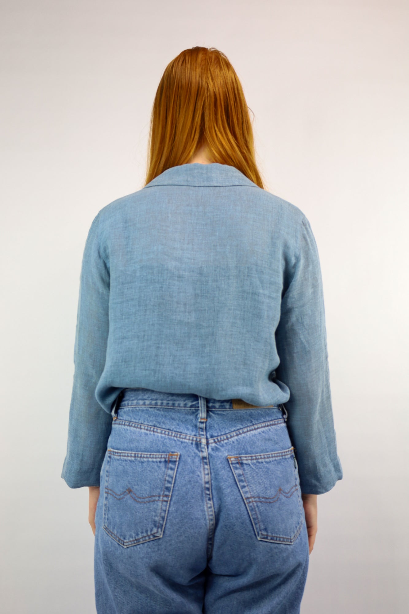 Achterkant van de lichtblauwe linnen blouse met drie kwart mouwen.