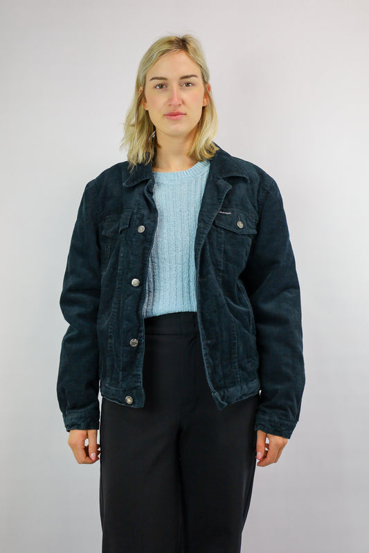 Voorkant van een vintage zwart corduroy jack met borstzakken en knoopsluiting.