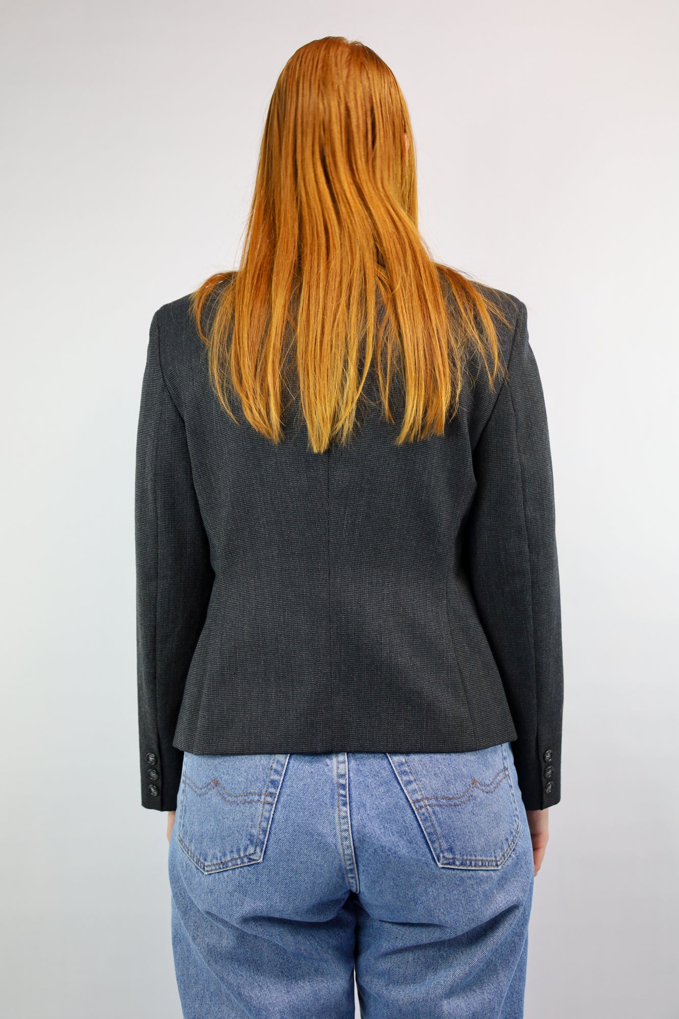Achterkant van gevoerde vintage damesblazer in zwart-grijs