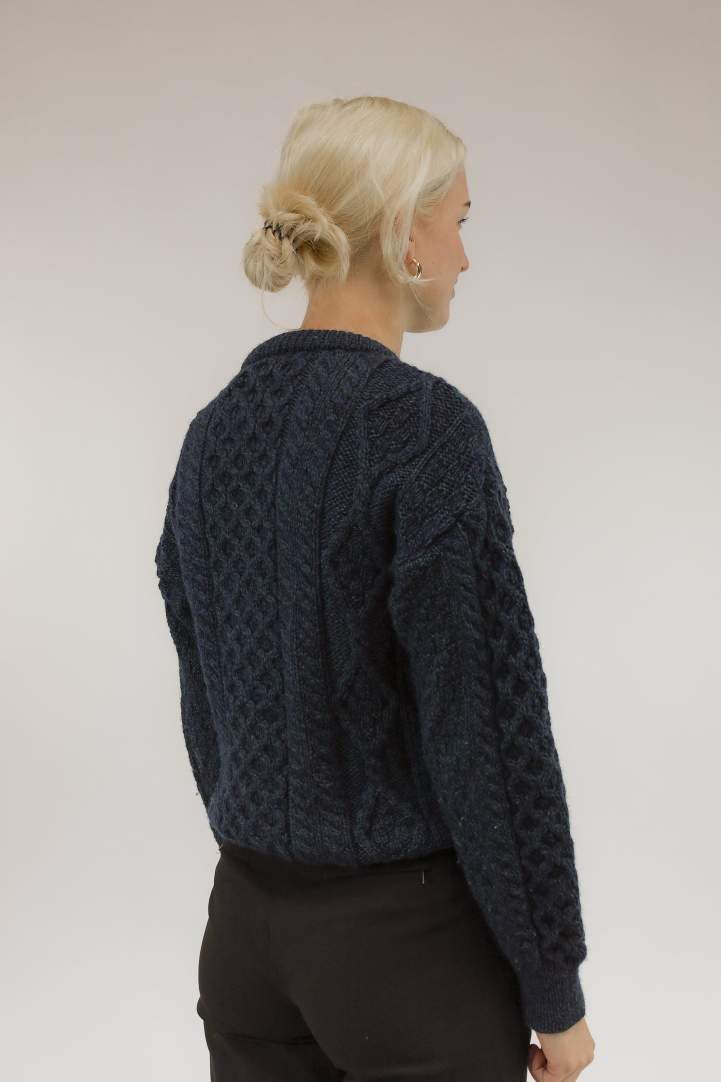 Achteraanzicht van model met vintage wollen trui in gemêleerde kleuren.