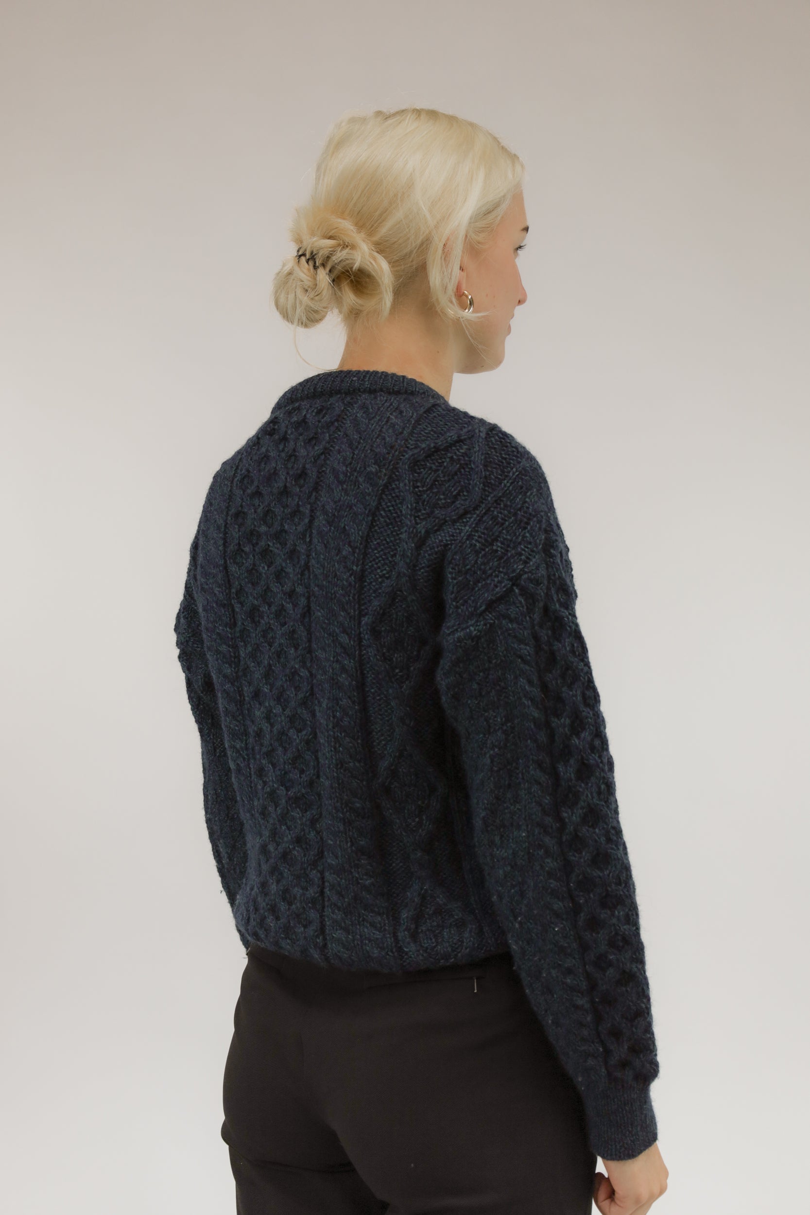 Achteraanzicht van model met vintage wollen trui in gemêleerde kleuren.