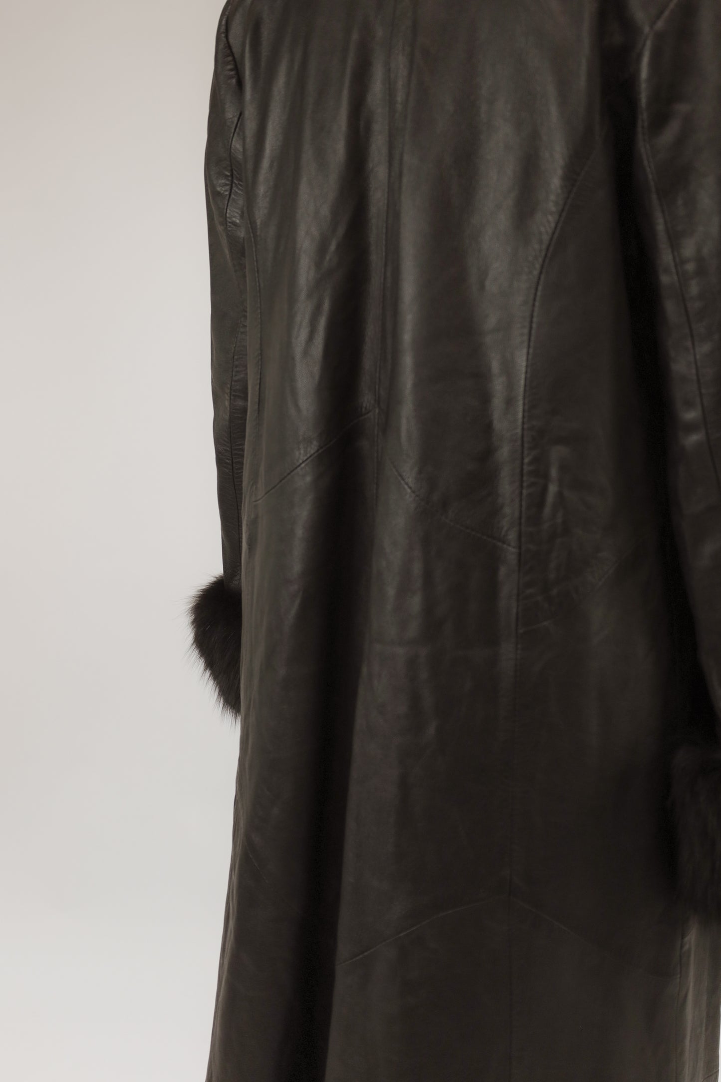 Close-up van model met vintage leren jas – detail van echte bontkraag en manchetten.
