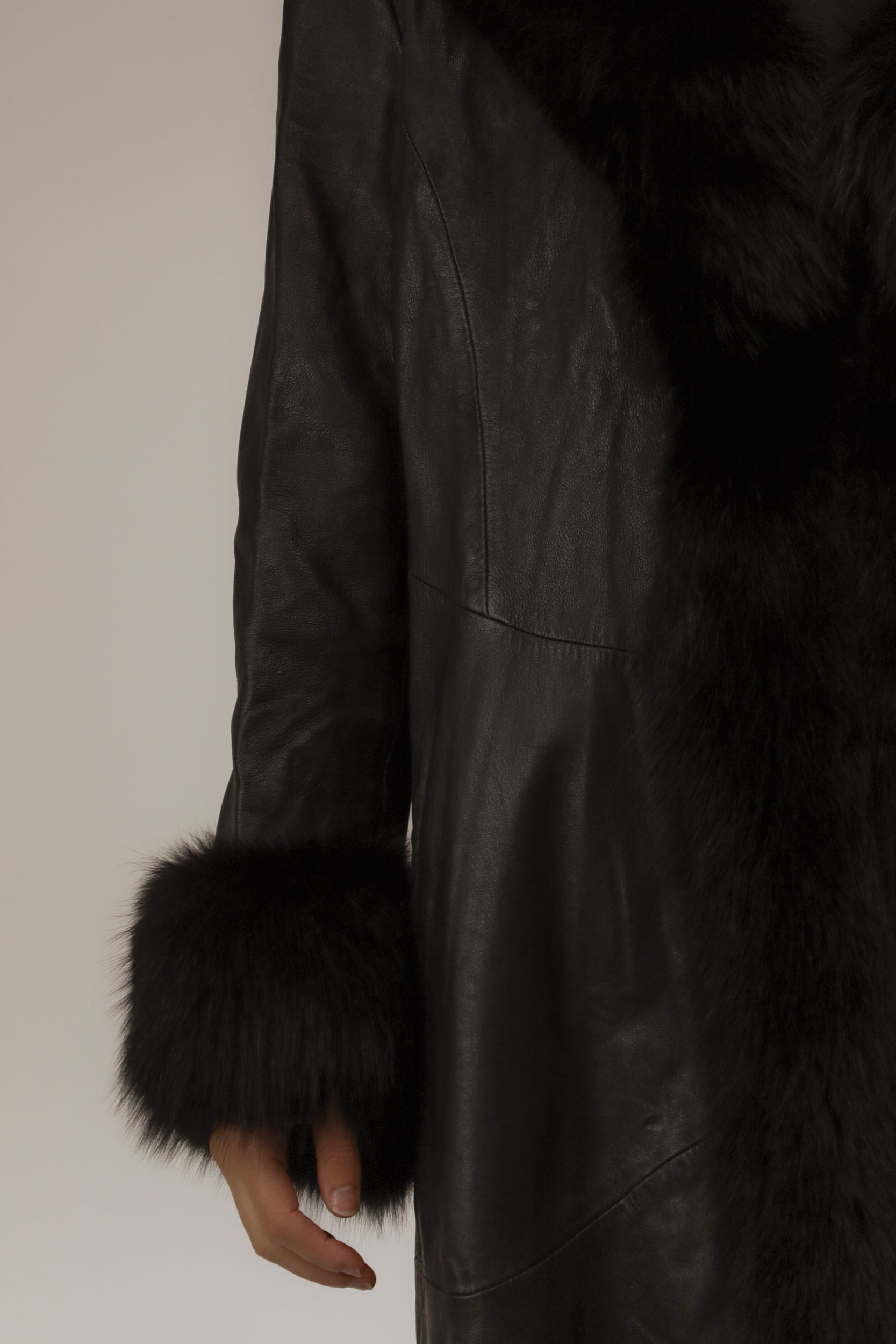 Close-up van model met vintage leren jas – detail van echte bontkraag en manchetten.